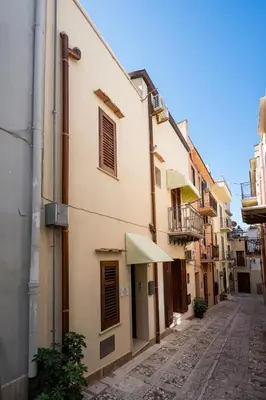 an alley in an old town with a building at Sofia Rooms in Castellammare del Golfo