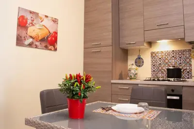 a kitchen with a table with a vase of flowers on it at Corso Alberto in terrazza Palermo in Palermo