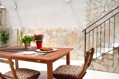 a wooden table with two chairs and a table with food on it at Corso Alberto in terrazza Palermo in Palermo