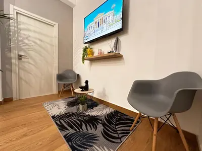 a living room with a tv and a chair and a rug at Ai Papiri in Palermo