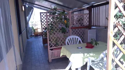 a table and chairs on a balcony with a fence at Camera a Palermo in Mondello