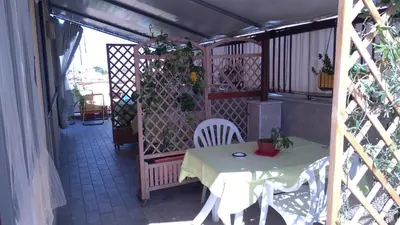 a table and chairs on a balcony with a fence at Camera a Palermo in Mondello
