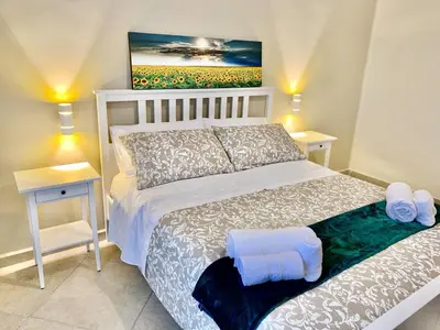 a white bed with towels on it in a bedroom at Central Apartment - Le Burnie in Palermo