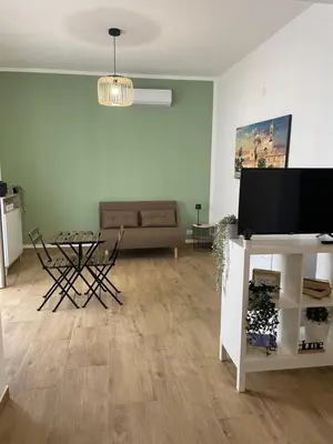 a living room with a couch and a table with a television at Dai Palermitani Rooms & Apartments in Palermo