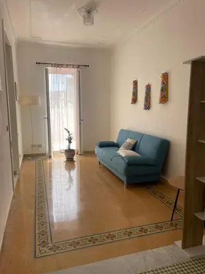 a living room with a blue couch and a window at Casa Marì Holiday House in Palermo