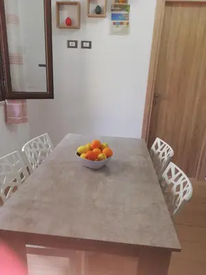 a bowl of fruit sitting on a table with chairs at Casa Vacanza Giulia in Castellammare del Golfo