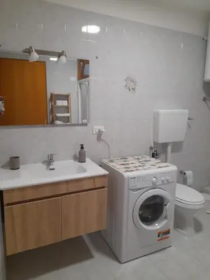a bathroom with a washing machine and a sink at casa vacanza tobruk in Castellammare del Golfo