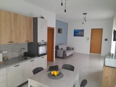 a kitchen and living room with a table and chairs at casa vacanza tobruk in Castellammare del Golfo