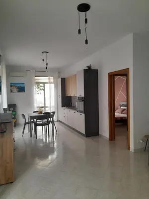 a kitchen and living room with a table and chairs at casa vacanza tobruk in Castellammare del Golfo
