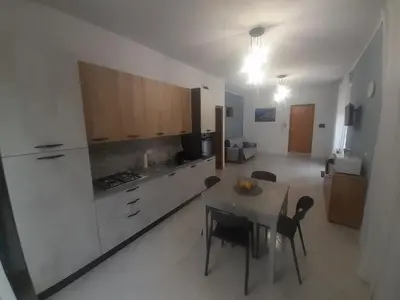 a kitchen with a table and chairs in a room at casa vacanza tobruk in Castellammare del Golfo