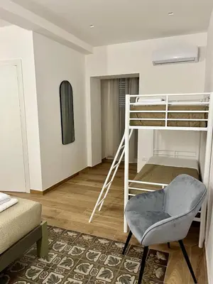 a bedroom with a bunk bed and a chair at Al Duomo Suites in Monreale