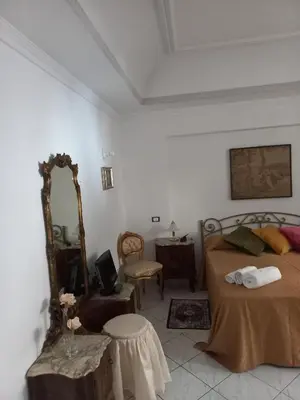 a bedroom with a bed and a mirror and a table at Al Palazzo Del Principe al Massimo in Palermo