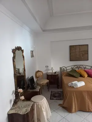 a bedroom with a bed and a mirror and a table at Al Palazzo Del Principe al Massimo in Palermo