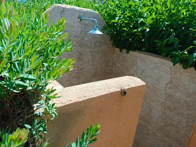 a shower with a light on a stone wall at Castellaccio Scopello Villetta con piscina in Scopello