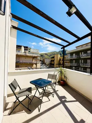 a patio with two chairs and a table on a balcony at Billy Home in Villabate