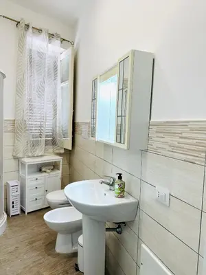a white bathroom with a sink and a toilet at Billy Home in Villabate
