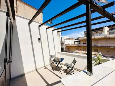 a balcony with two chairs and a table on a building at Billy Home in Villabate