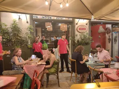 a group of people sitting at tables in a restaurant at La dimora di Elma in Palermo