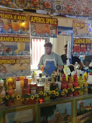 two men standing behind a counter with bottles of alcohol at La dimora di Elma in Palermo