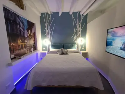 a bedroom with a bed with purple lights on it at Agghiorna&skura 2,0 in Palermo