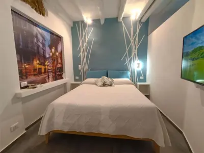 a bedroom with a bed in a room with a tv at Agghiorna&skura 2,0 in Palermo