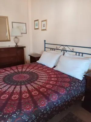 a bedroom with a bed with a red blanket and white pillows at Terrazza Mare Mondello in Palermo