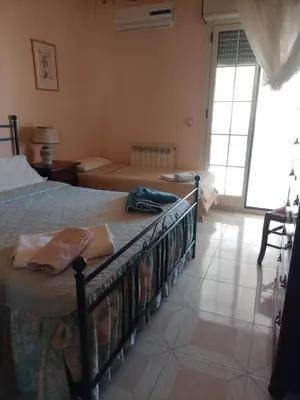 a bedroom with two beds and a large window at Terrazza Mare Mondello in Palermo