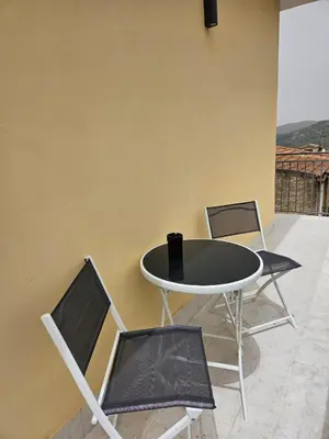 a table and chairs sitting next to a wall at Flowers Apartments in Marineo