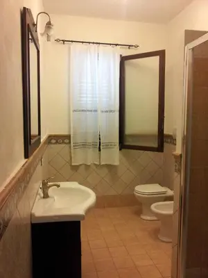 a bathroom with a sink and a toilet and a mirror at VILLA BUTTERFLY 2 a FEW STEPS FROM THE SEA in Capaci