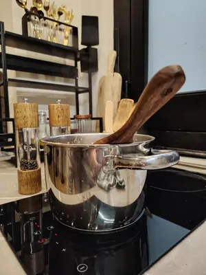 a pot on a stove with a wooden spoon in it at Casa O'Tama in Palermo
