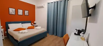 a bedroom with a bed with orange and blue curtains at Molinari Palermo in Palermo