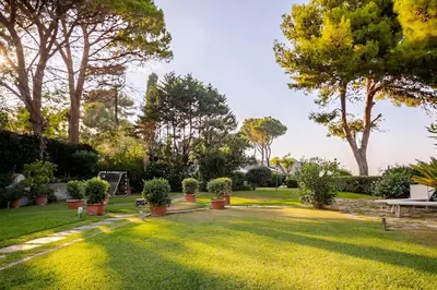 a garden with potted plants on the grass at Alle due Torri, villa sulla roccia a picco sul mare in Altavilla Milicia