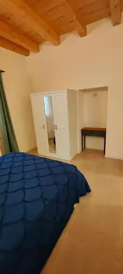 a bedroom with a blue bed and a table at Crihouse in Palermo