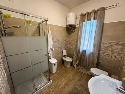a bathroom with a shower and a toilet and a sink at Intero Appartamento con Terrazza - Villa Ciaculli in Palermo