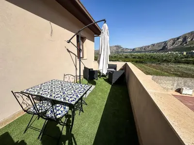 a table and chair on a balcony with an umbrella at Intero Appartamento con Terrazza - Villa Ciaculli in Palermo