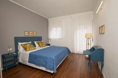 a bedroom with a blue bed and two night stands at Nothotel delle Rose in Palermo