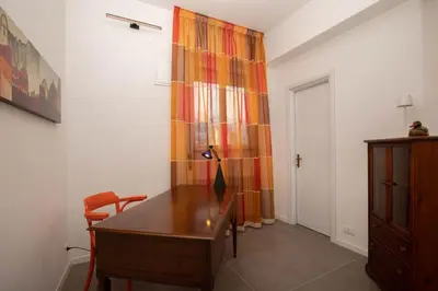 a room with a wooden desk and a curtain at Nothotel delle Rose in Palermo