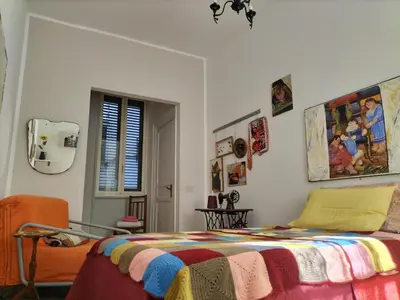 a bedroom with a bed with a colorful blanket at Casa Dam'Arte in Palermo