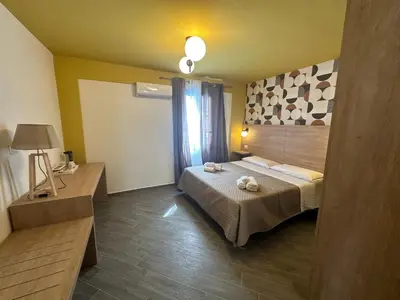 a bedroom with a bed and a table and a lamp at Intero Appartamento con Solarium - Villa Ciaculli in Palermo