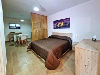 a bedroom with a large bed and a dining room at DIMORA SAITTA per SAITTA HOLIDAYS in Palermo