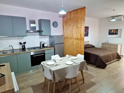 a kitchen and a bedroom with a table and chairs at DIMORA SAITTA per SAITTA HOLIDAYS in Palermo