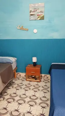 a bedroom with a bed and a table with a lamp at LA TERRAZZA SUL MARE camera doppia vicino aereoporto&mare SICILIAN SEA STYLE ROOM in Cinisi