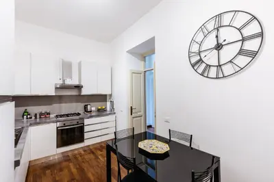 a kitchen with a table and a clock on the wall at Piazza Marina Suite By DomuSicily in Palermo