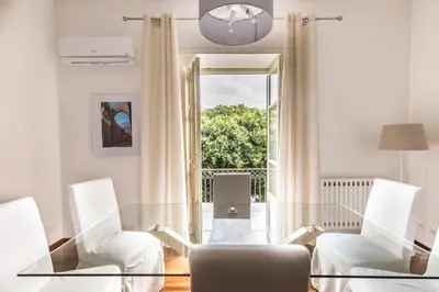 a living room with a glass table and two chairs at Piazza Marina Suite By DomuSicily in Palermo