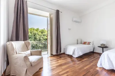 a white room with a chair and a bed and a window at Piazza Marina Suite By DomuSicily in Palermo