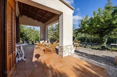 a patio with chairs and tables on a house at La Gurra Tenuta Migliore By DomuSicily in Chiusa Sclafani