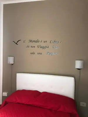 a bedroom with a bed with a writing on the wall at Little house of Grandpa Antonio in Palermo