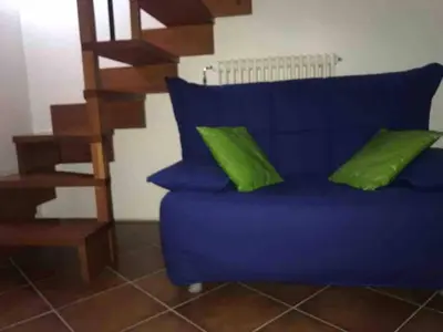 a blue couch with green pillows in a living room at Little house of Grandpa Antonio in Palermo
