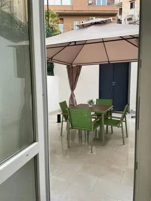 a patio with a table and chairs and an umbrella at La Quas at in Palermo