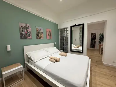a bedroom with a large white bed and a mirror at La Quas at in Palermo